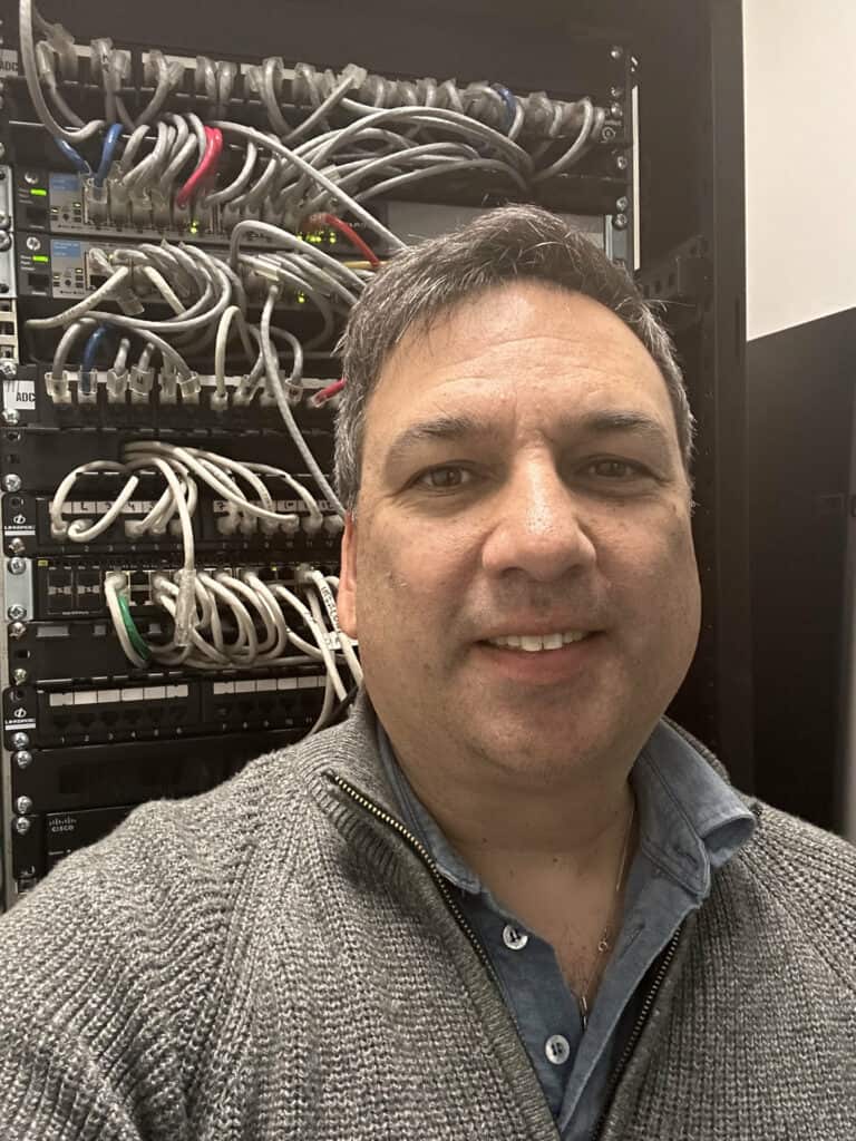 Axin found Sheldon Cairns in front of a network cabinet